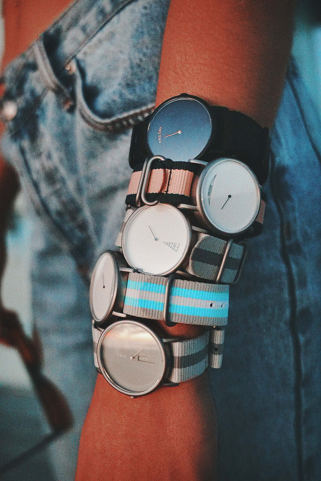 Daywatch watches collection — multiple watches stacked on wrist wearing denim
