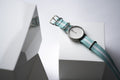 The Point White by Daywatch — studio hero shot on geometric white surface with teal NATO strap