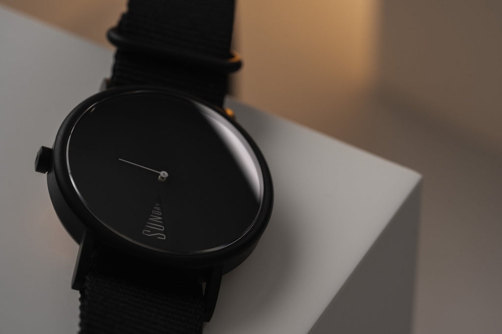 The Point Black by Daywatch — hero studio shot showing all-black dial and case on geometric surface